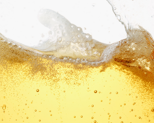 Close-up of a glass of beer with foam and bubbles.