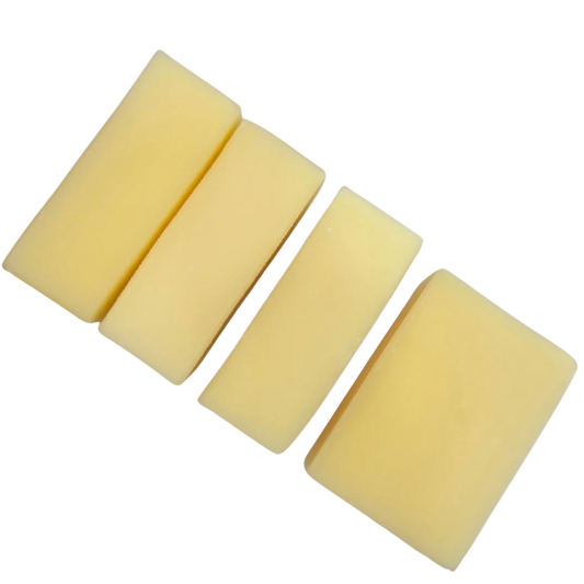 four rectangular light yellow soaps on a white background