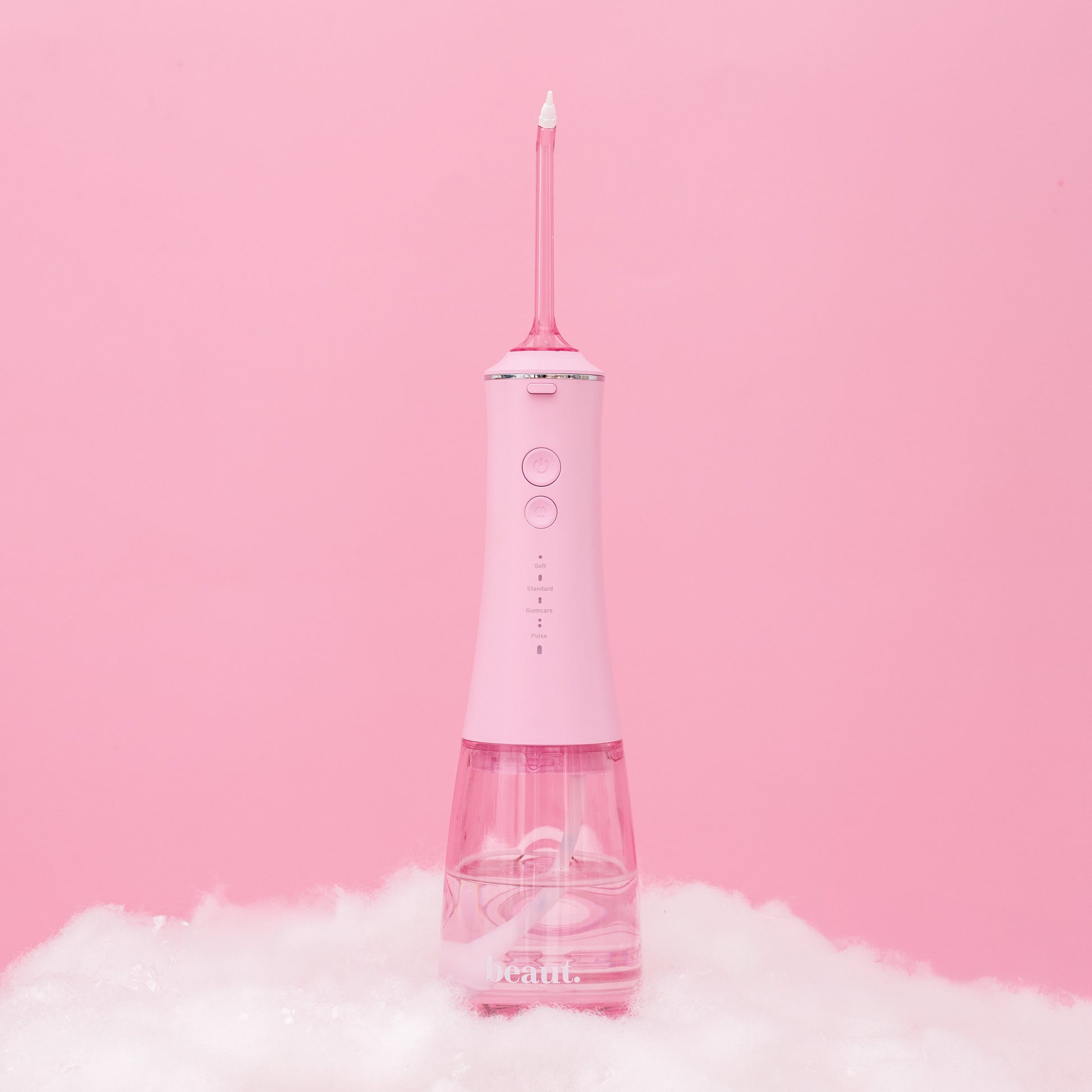 Pink dental water flosser on a pink background