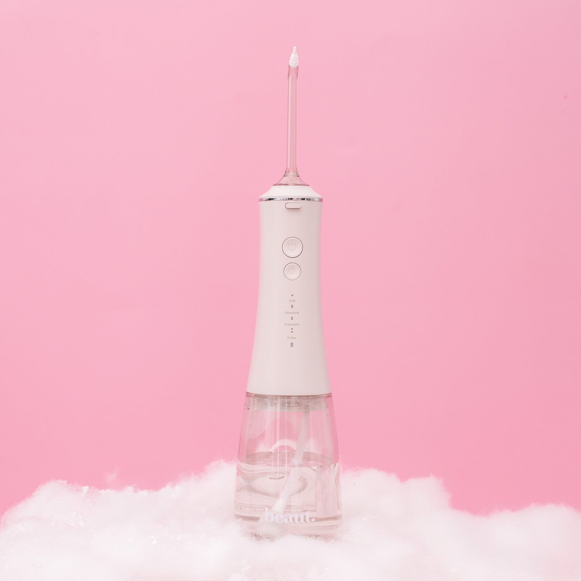 White dental water flosser on a pink background