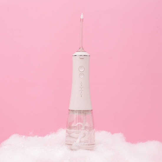 White dental water flosser on a pink background