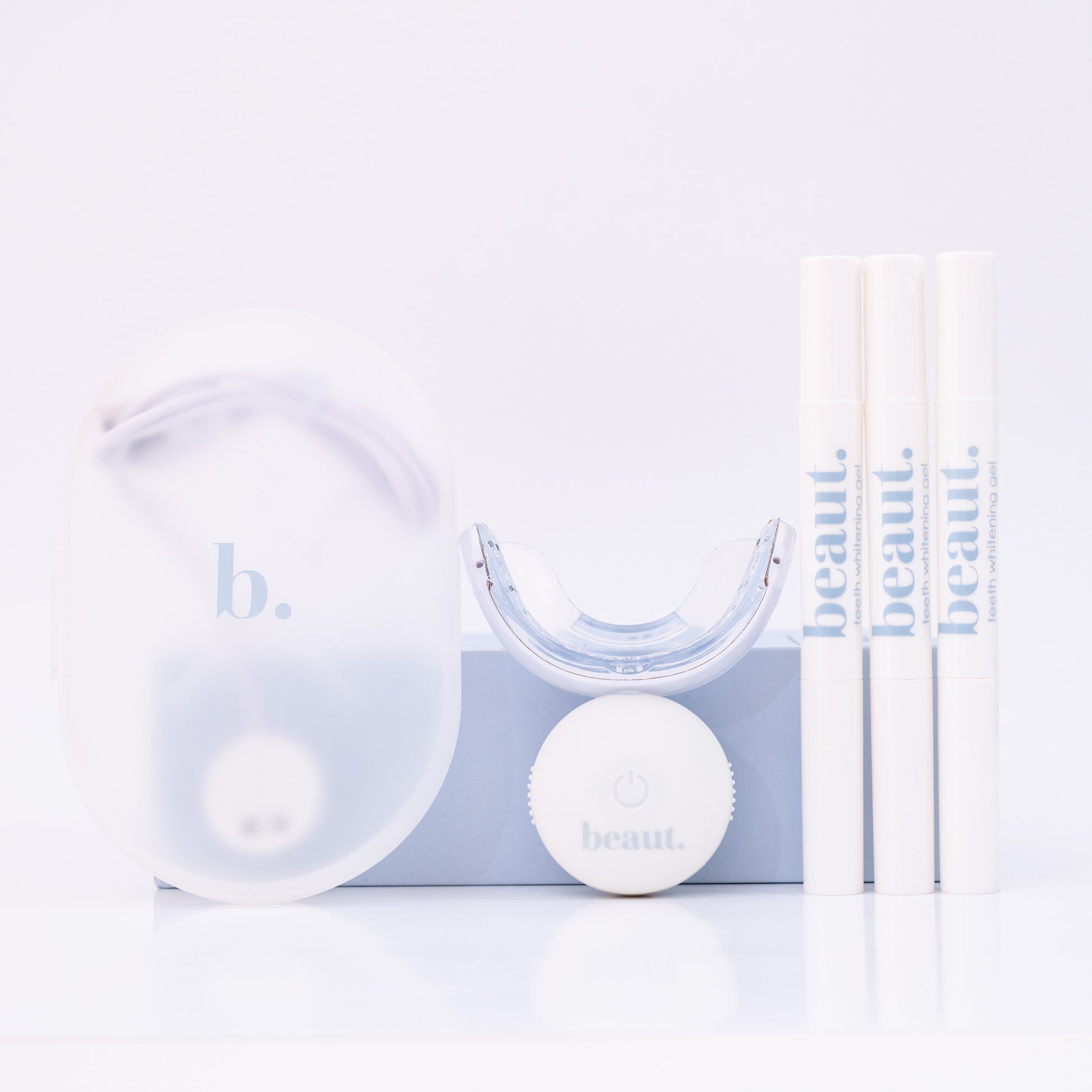 Clear dental device with white ball and packaging on a light blue background