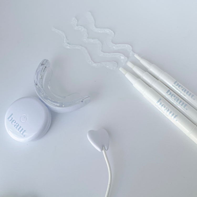 Cosmetic product with applicator and lid on a white background