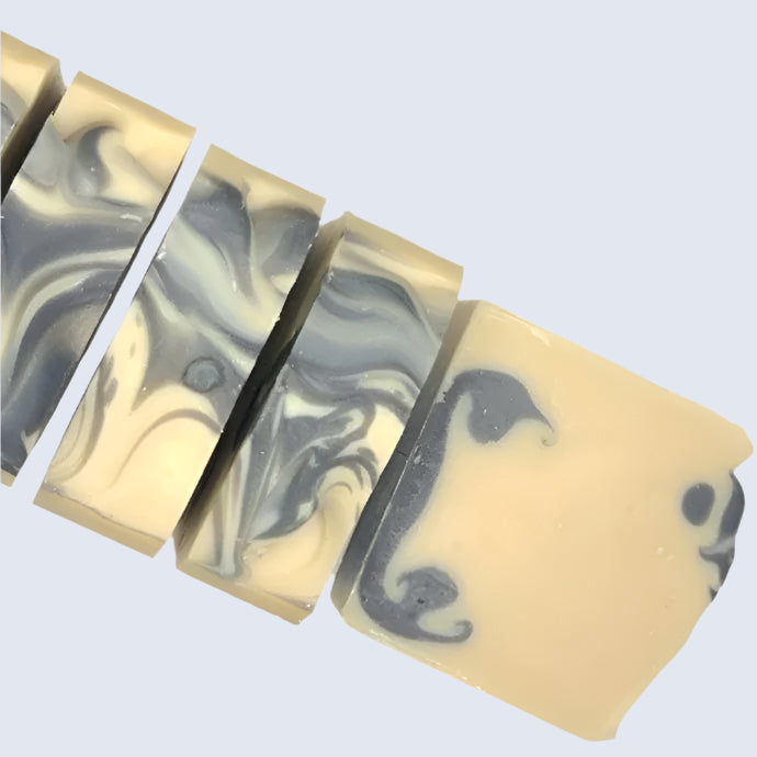 Marbled soap bars with black and gray swirls on a white background