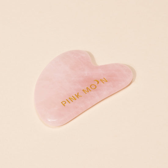 Heart-shaped pink tool with 'PINK MOON' text on a beige background