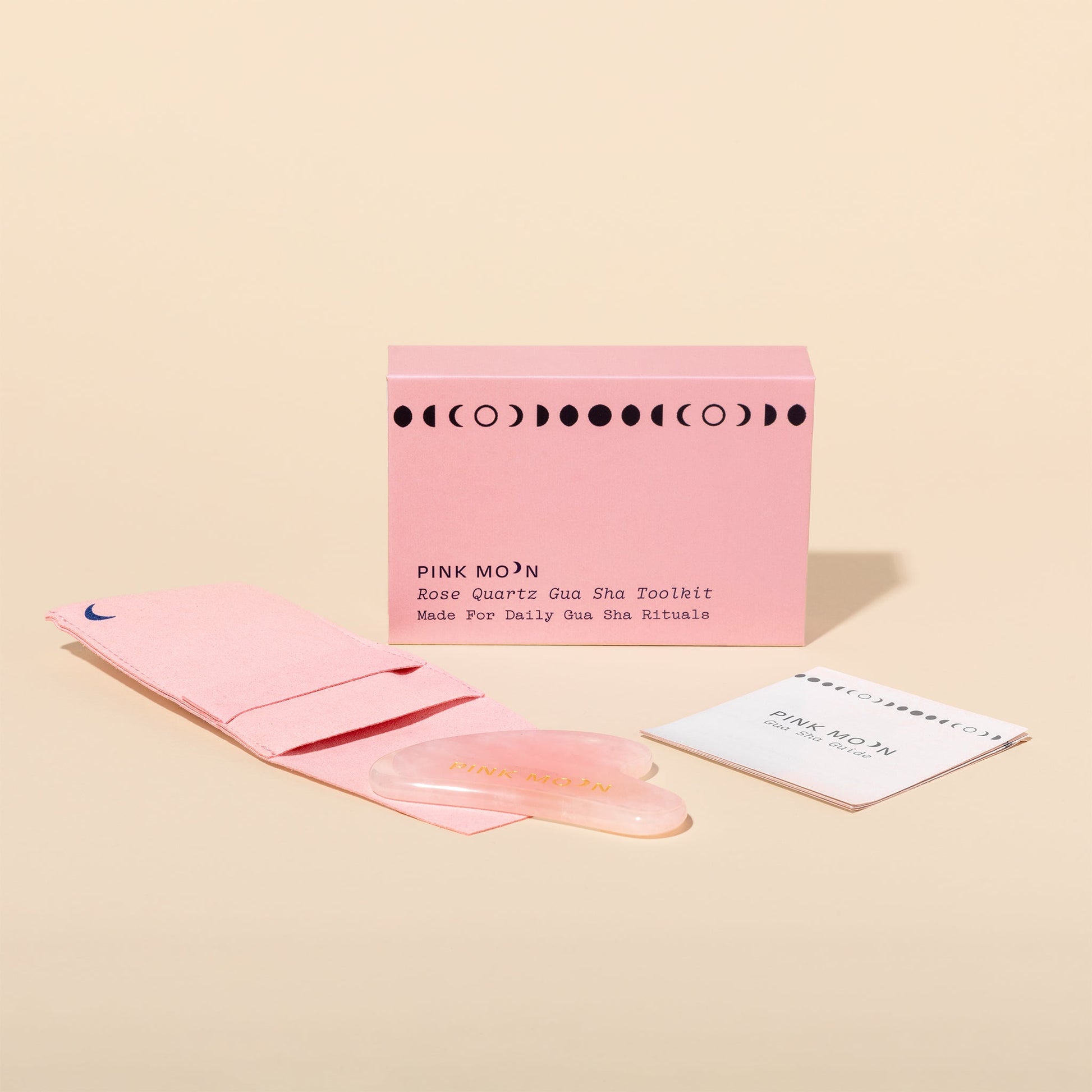 Pink Mo'N Gua Sha Toolkit with packaging on a beige background